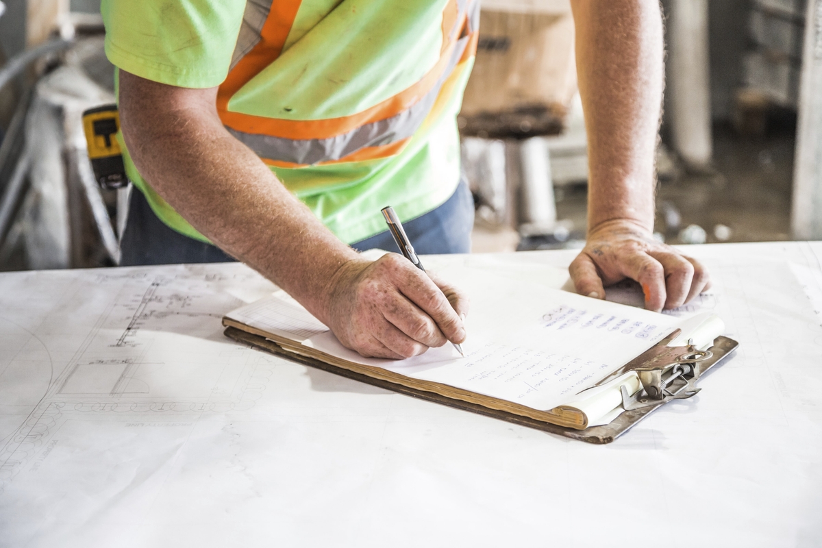 A construction worker goes over plans on site of a condominium build